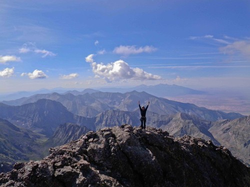 Student celebrates on top of a mountain