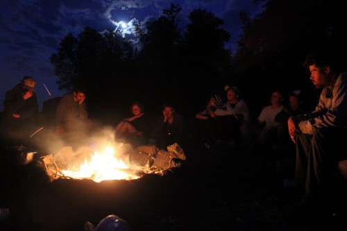 Students warm up around a fire. Photo by Caroline Callahan