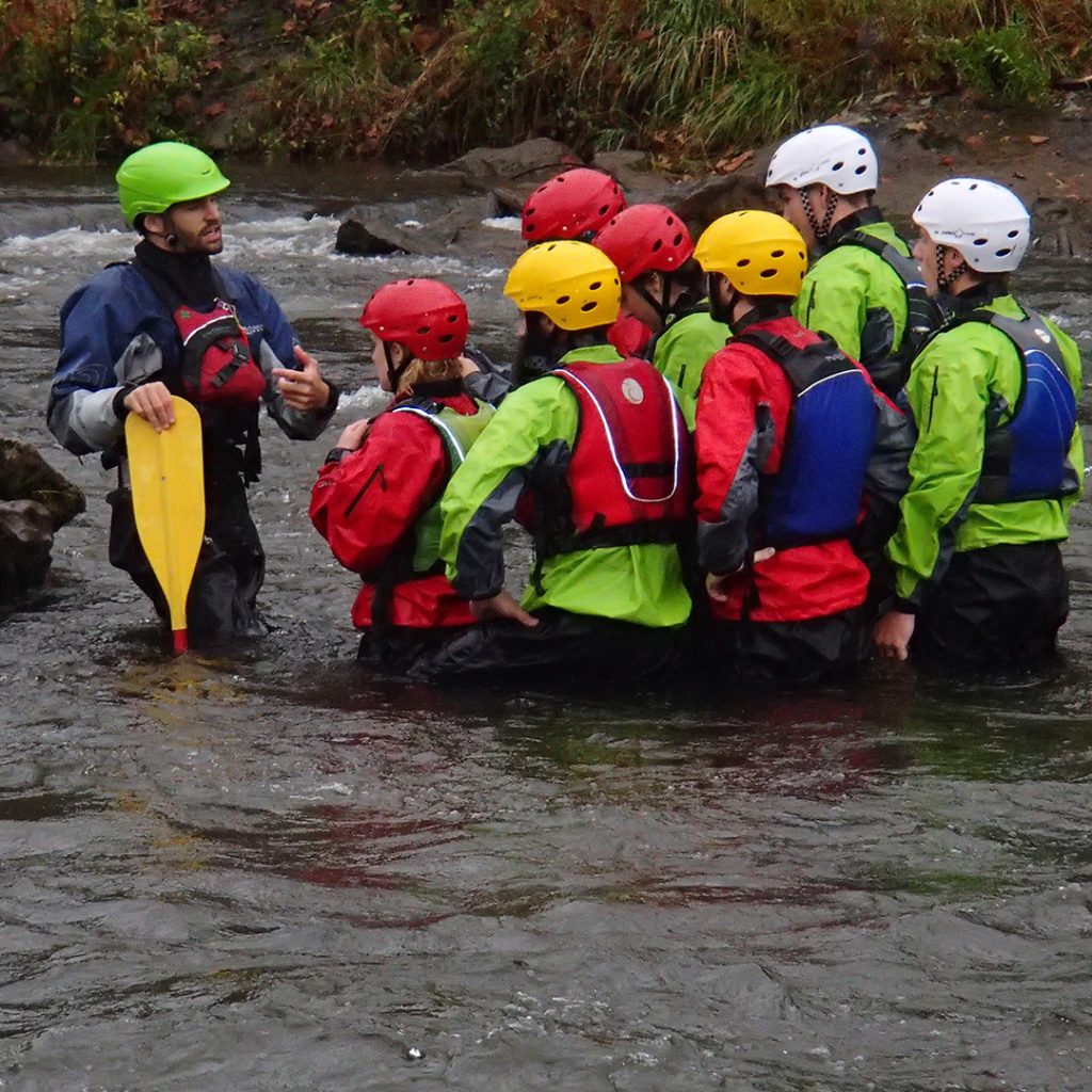 An Outward Bound Instructor reviews safety and paddling techniques with students.