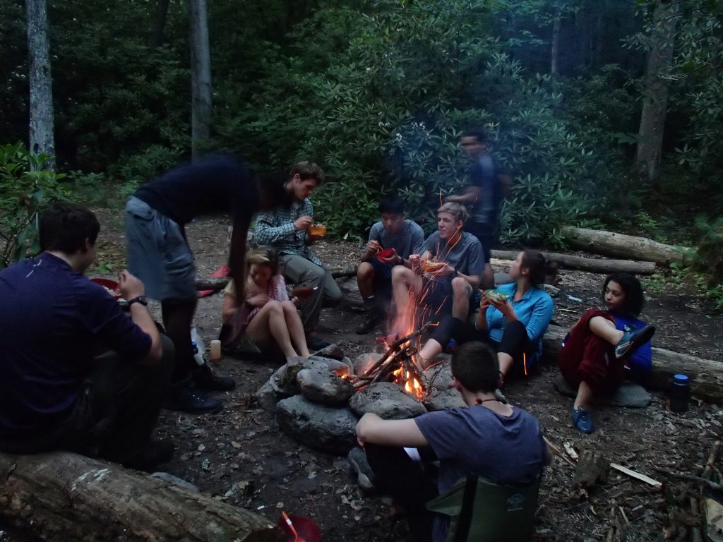 Students sit down to a meal after a day of backpacking.