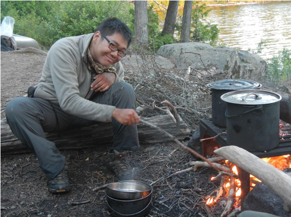 A student cooks over the fire in the Boundary Waters, Minnesota. Photo courtesy of Theo Theobald.