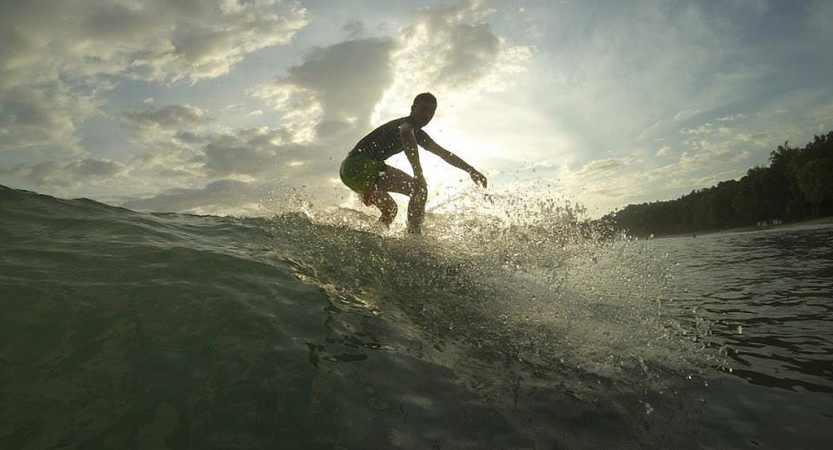 A person rides a wave on a surfboard 