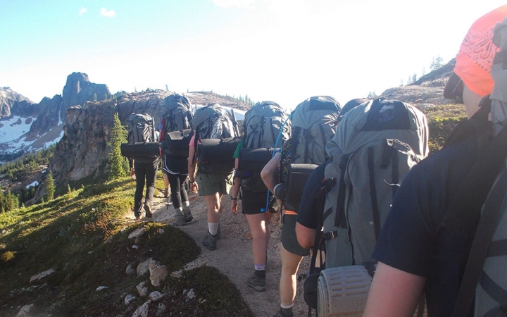 a group of veterans make their way along a trail on an outward bound course