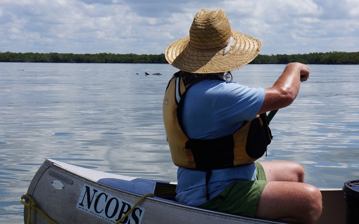 a person paddles a canoe on an outward bound veterans expedition
